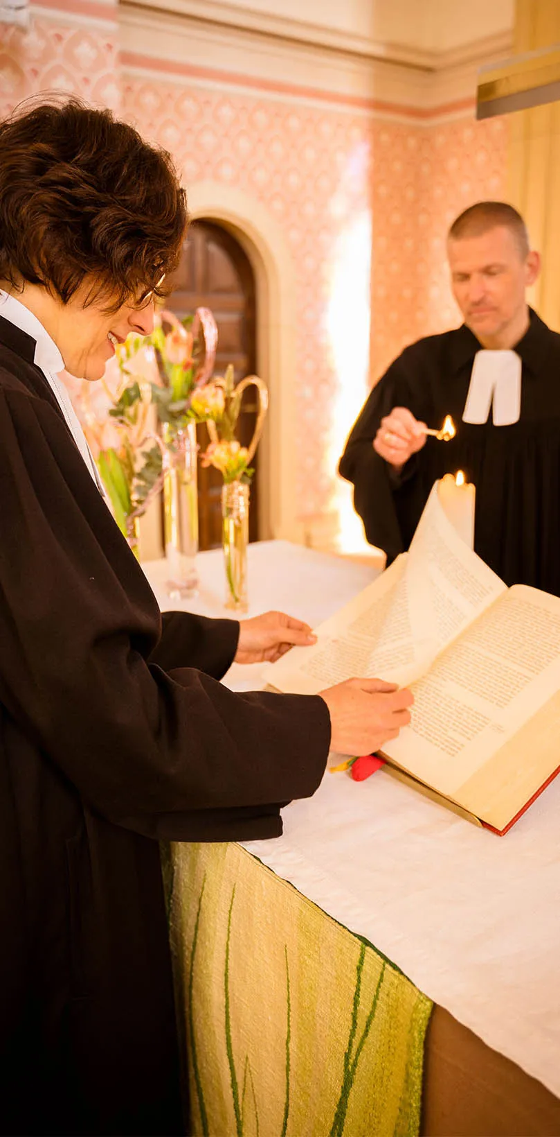 Pfarrerin und Pfarrer richten den Altar